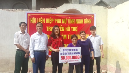 Lãnh đạo Hội Phụ nữ và các đồng chí trong Ban Kiến thiết xây dựng nhà trao hỗ trợ cho bà Đinh Thị My