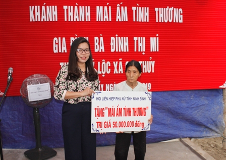 Đồng chí Vũ Thị Hà, Phó Chủ tịch Hội LHPN tỉnh trao tiền hỗ trợ xây dựng MATT cho gia đình bà Đinh Thị My.