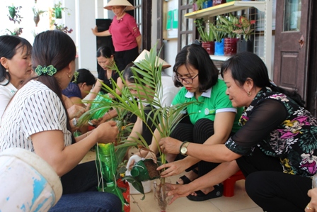 Lãnh đạo Hội LHPN tỉnh cùng chị em hội viên phụ nữ xã Kim Tân, huyện Kim Sơn trồng cây vào các chai, lọ nhựa tái chế.
