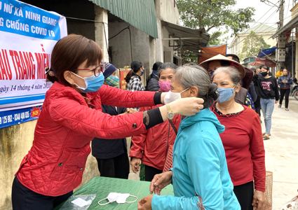 Phụ nữ xã Ninh Giang (Hoa Lư) phát khẩu trang miễn phí và hướng dẫn người dân đeo khẩu trang đúng cách.