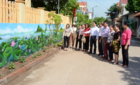 Các đại biểu tham quan mô hình "Nhà sạch, vườn đẹp, tường bích họa" tại thôn Đông Thành, xã Trường Yên.