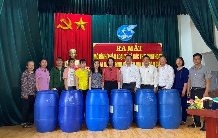 Các đồng chí lãnh đạo Hội LHPN tỉnh, Hội LHPN huyện và Đảng ủy HĐND, UBND xã trao tặng thùng rác cho các hộ tham gia mô hình